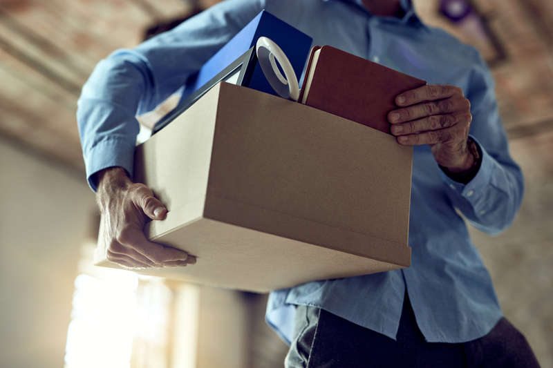 Unrecognizable businessman carrying his belongings after being f